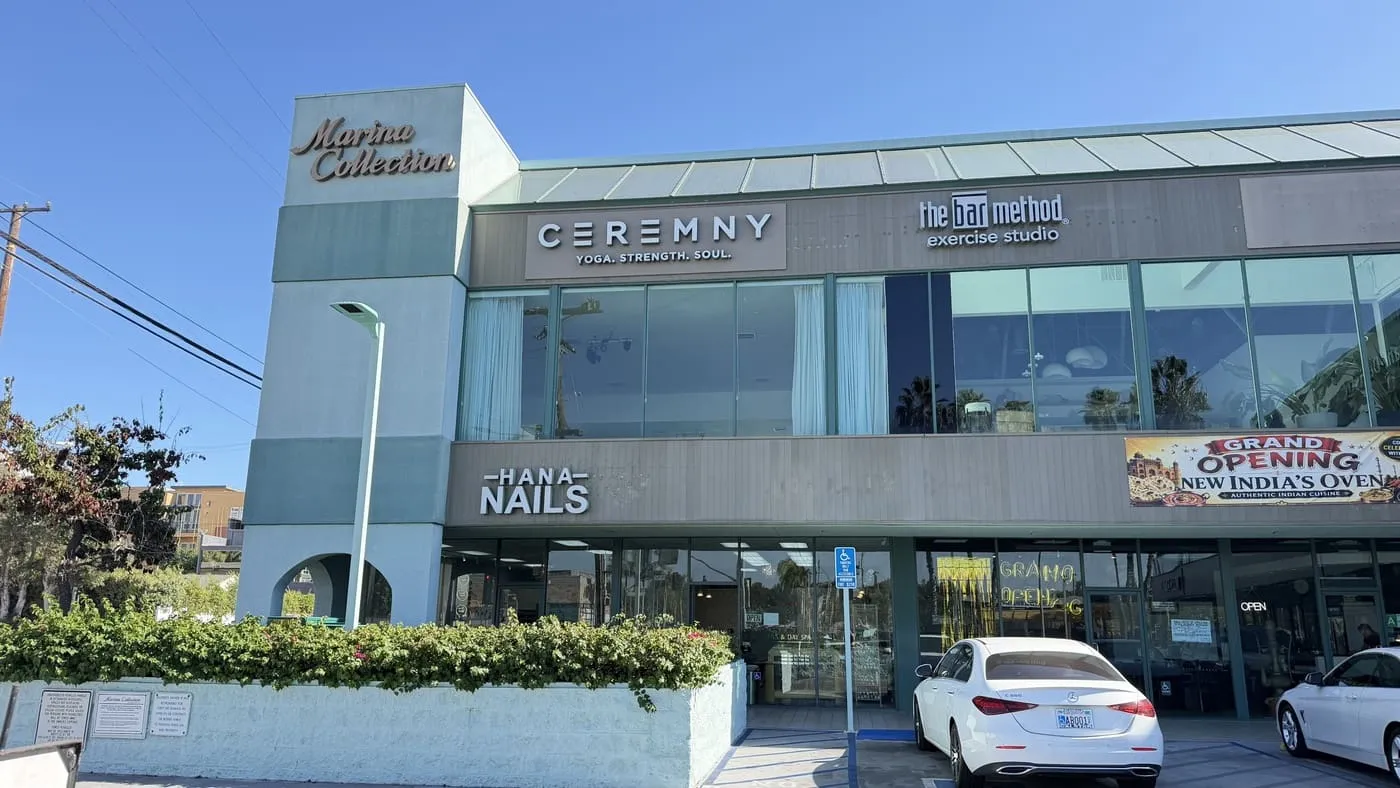The street front on Washington Blvd: the CEREMNY sign and its tagline on the first floor of the Marina Collection building, with a parking lot below