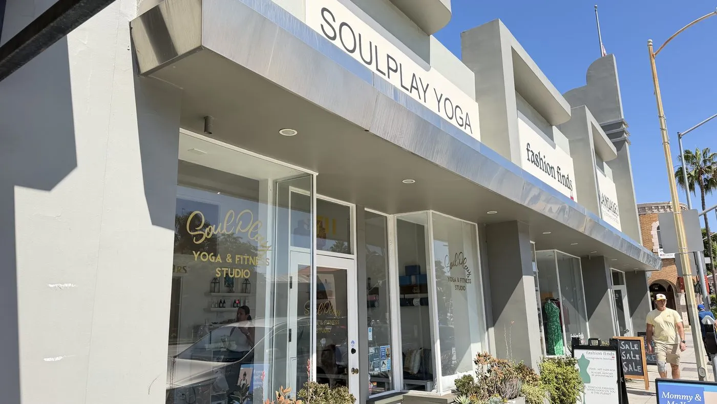The studio seen along Washington Boulevard, its awning and sign among the neighbouring shopfronts with palm trees at the end of the block